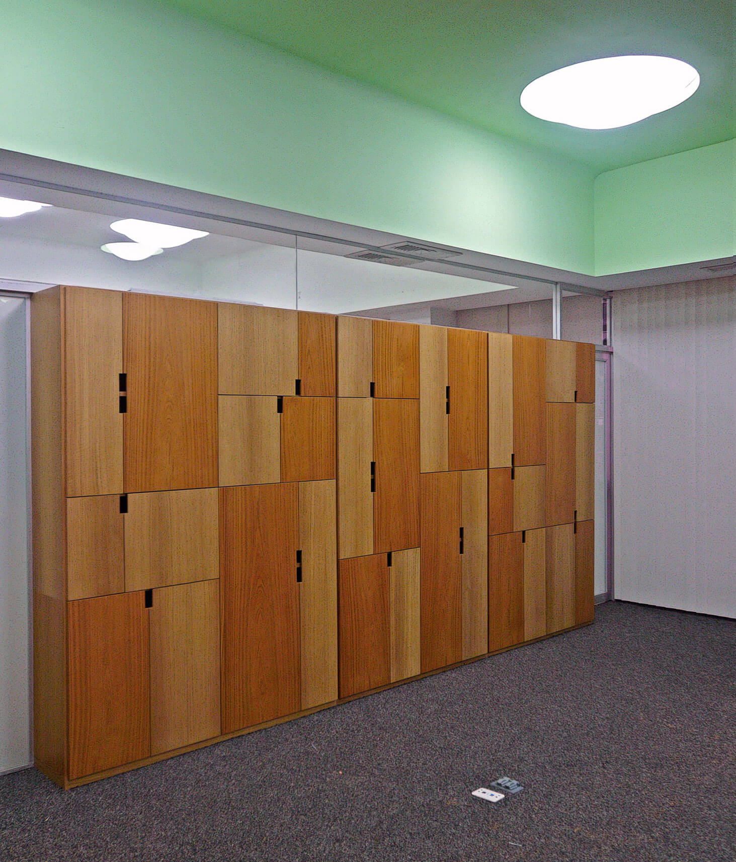 Reforma de oficinas: muebles de diseño modulares de madera en dos tonos y techos de colores para dividir las áreas de trabajo