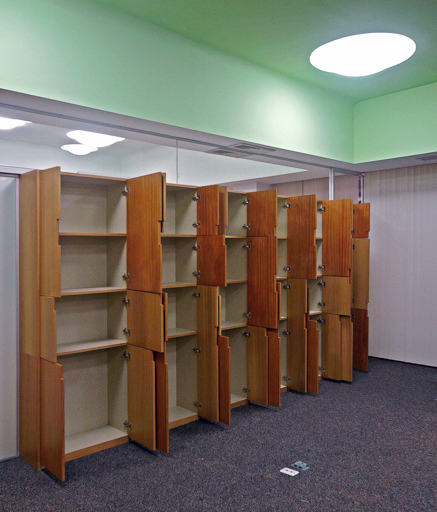 Diseño de las oficinas de Medifarm. Como si fuesen muros, los muebles de madera dividen las áreas de trabajo