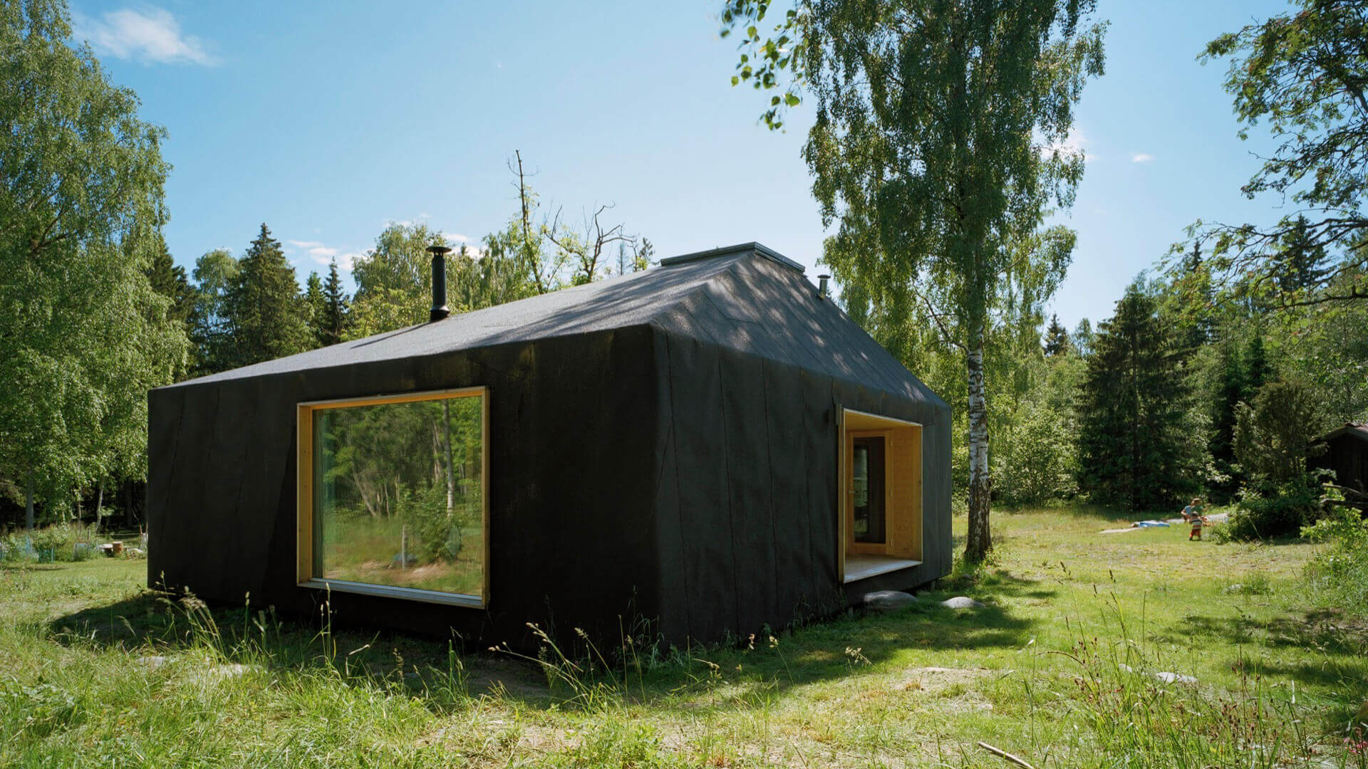 Casa pequeña de verano en Söderöra, con grandes ventanales y diseño arquitectónico integrado al paisaje.
