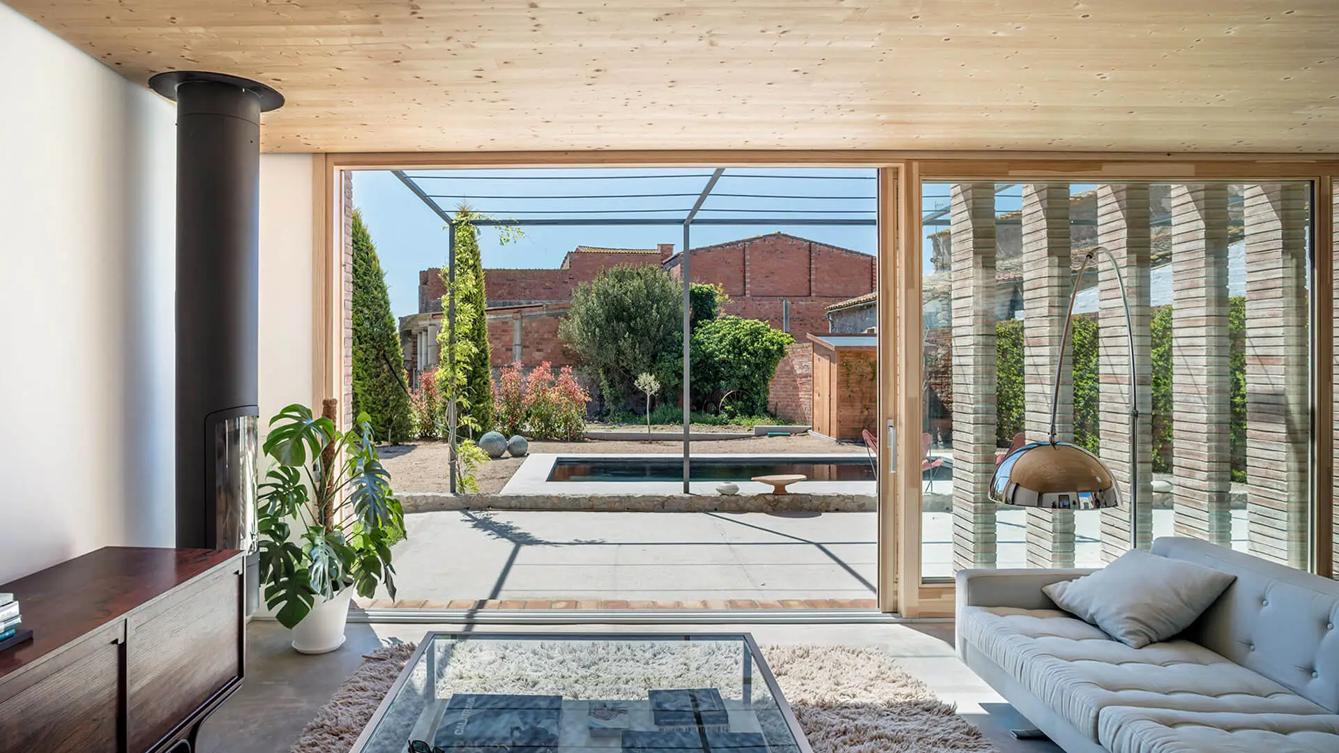 Diseño de casa de una planta con piscina y gran ventanal que conecta el salón con el jardín y la terraza.