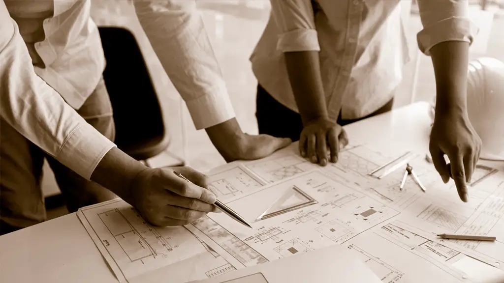 Arquitectos revisando planos detallados de construcción de una vivienda unifamiliar, planificación del diseño arquitectónico.